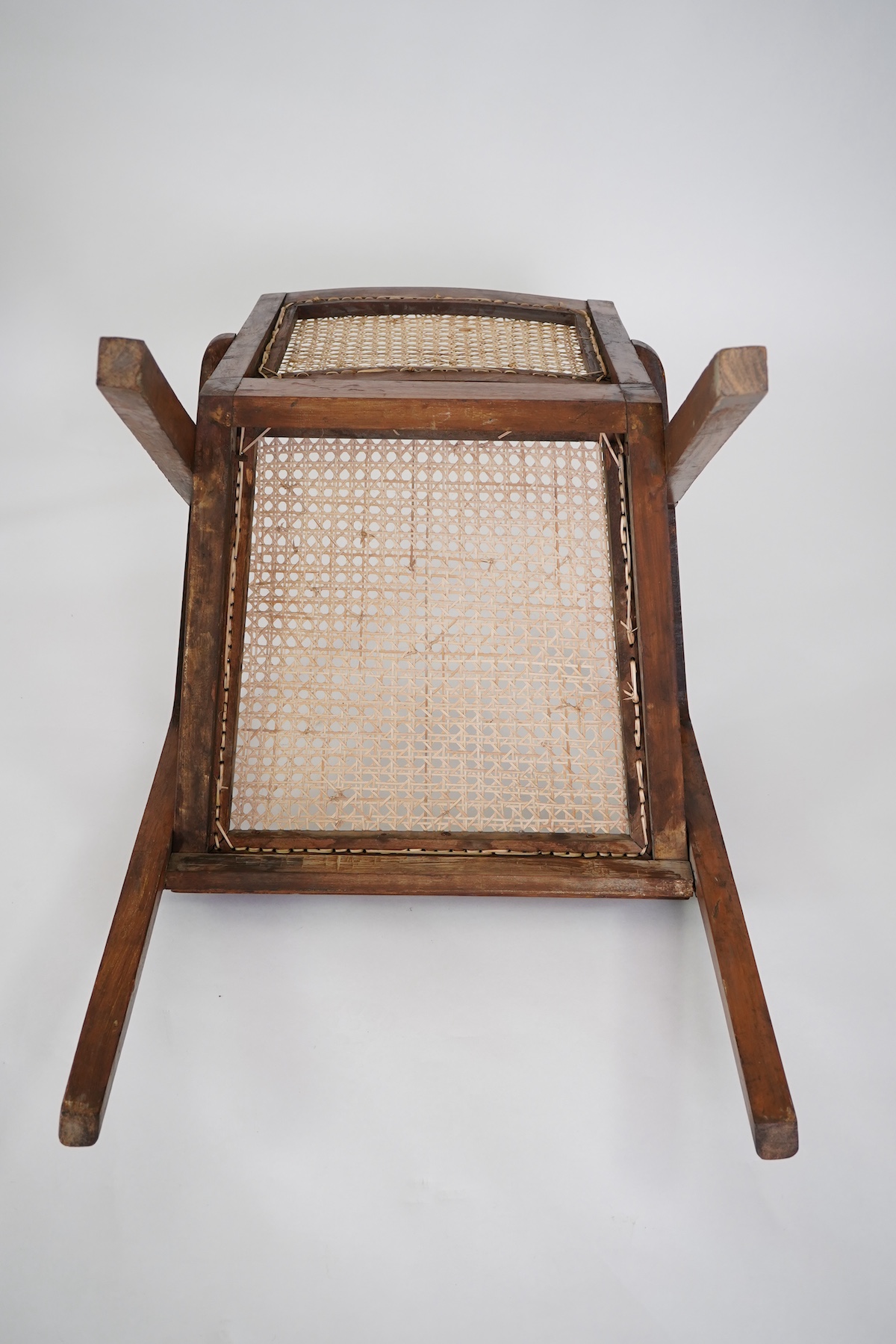 Manner of Pierre Jeanneret (Swiss, 1896-1967): A set of four solid teak and braided canework armchairs